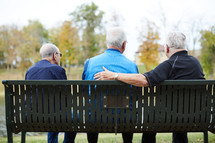 elderly men talking outdoors 