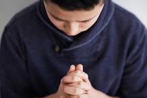 a boy with head bowed in prayer 