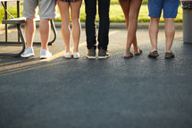 legs of a group of young adults standing together 