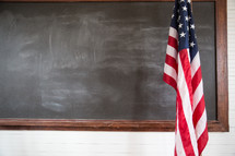 American flag and blackboard in a schoolhouse. 