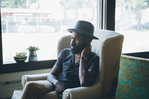 African American man sitting in an armchair in a coffee shop 