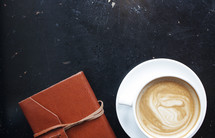 coffee cup and leather bound journal 