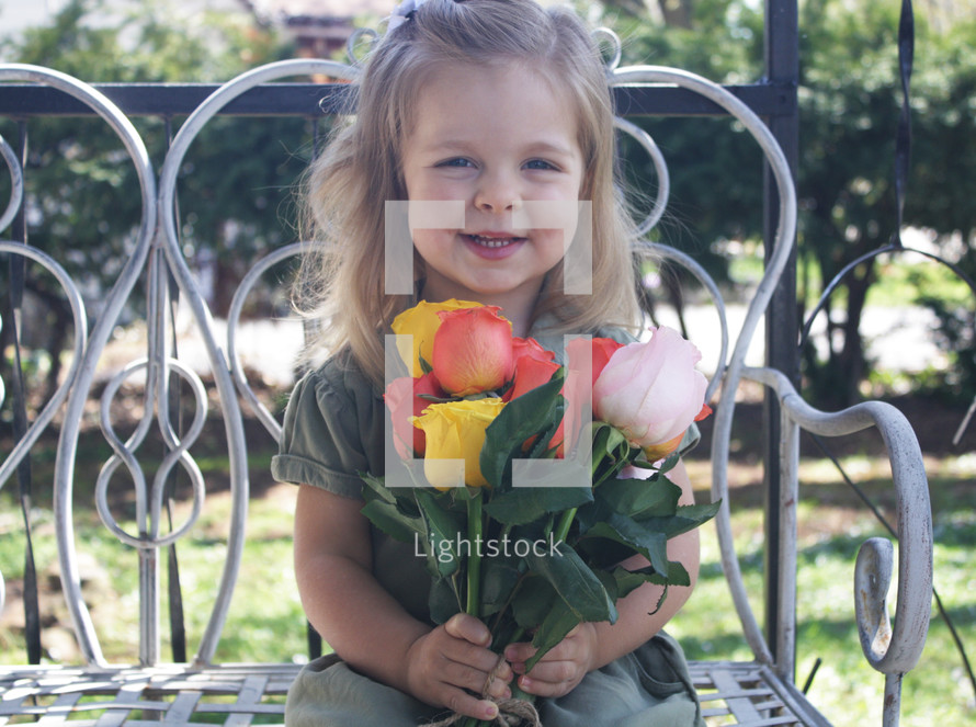a little girl holding a bouquet of tulips for mom 
