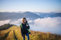 a teen girl walking on a mountaintop 