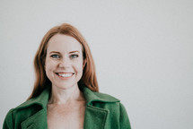 woman in a green blazer smiling 