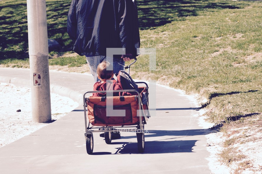 a father pulling his kids in a wagon 