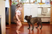 a toddler girl and a french bulldog 