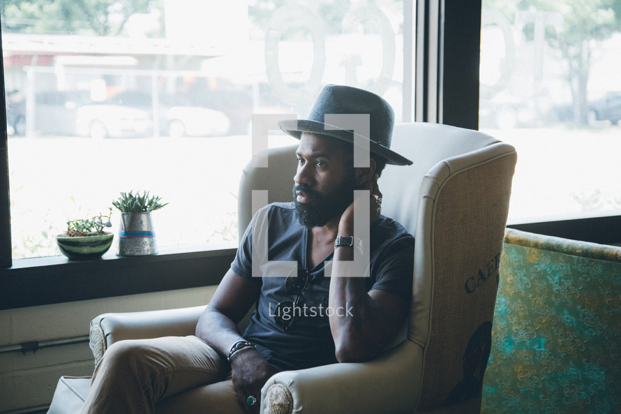 African American man sitting in an armchair in a coffee shop 