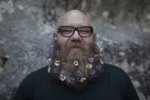 man with a thick beard with flowers 