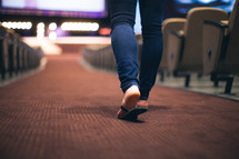 woman's feet walking down the aisle of a church 