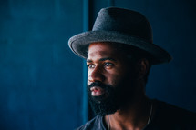 African American man with a thick beard wearing a hat 