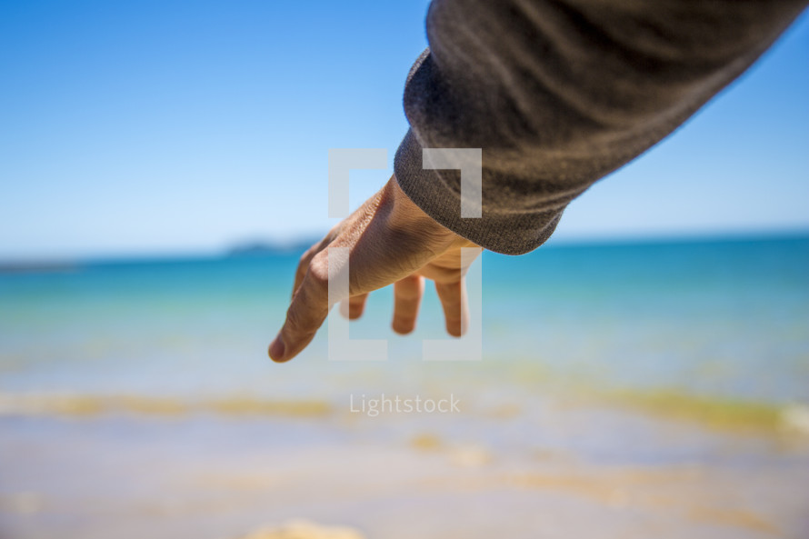 outstretched hand and ocean water 