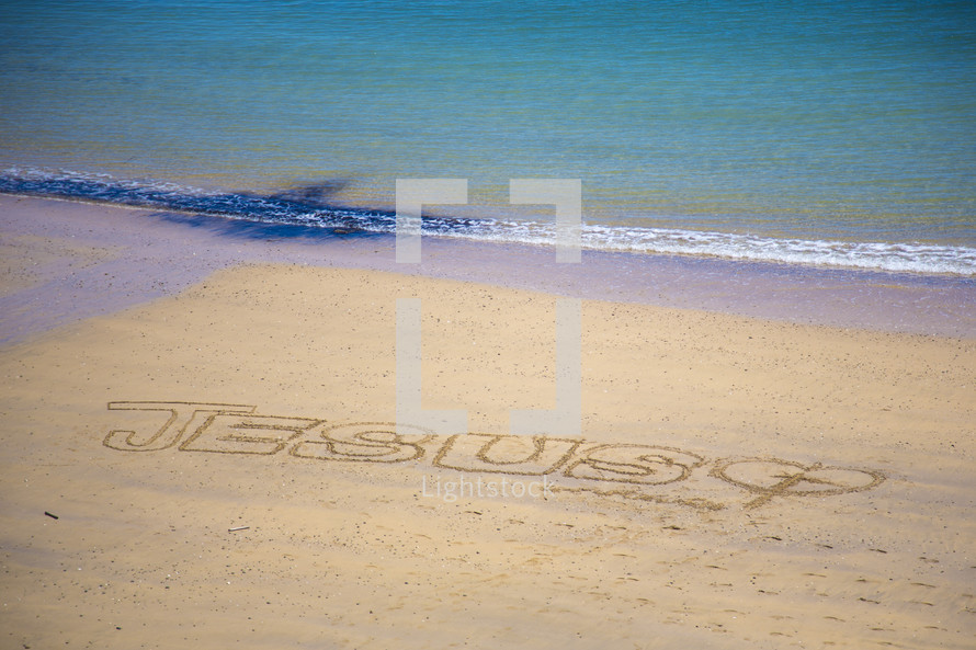 Jesus written in the sands of a beach 
