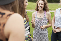 Young woman talking to a group of other women, standing outside