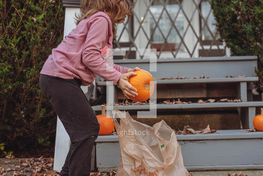 girl decorating with pumpkins 