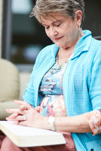 woman praying with hands over a Bible 
