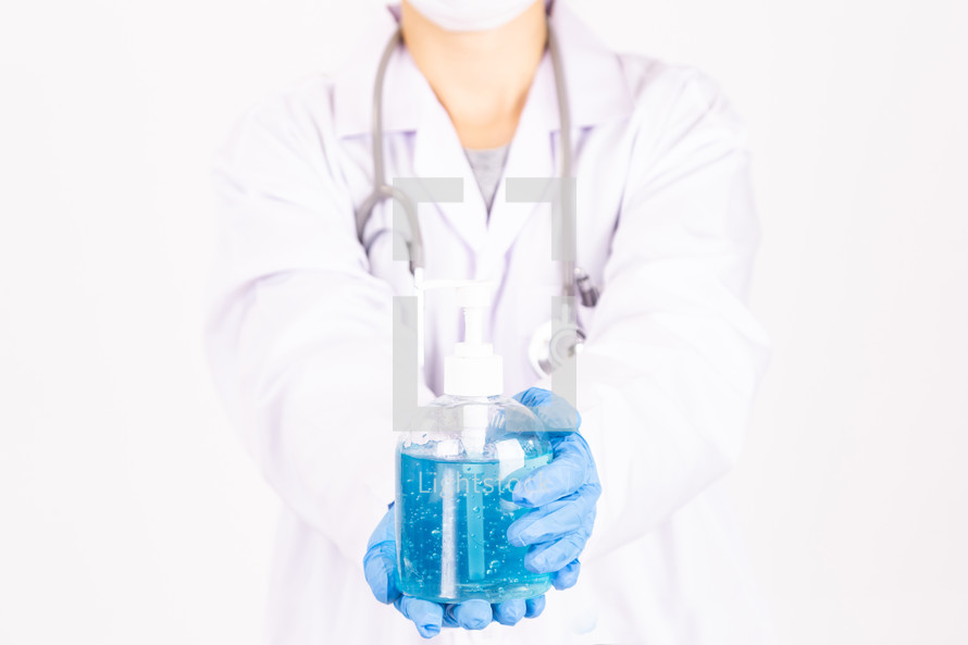 a female doctor holding hand sanitizer 
