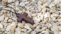 wooden cross necklace in gravel 
