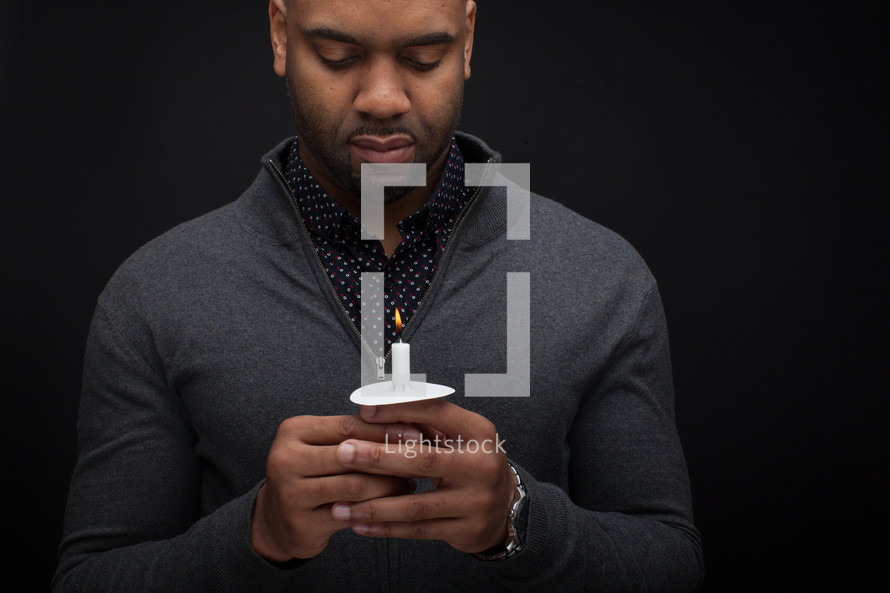 an African American man holding a candle 
