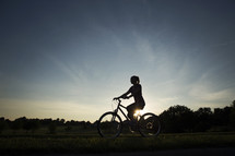 woman riding a bike at sunset 