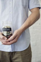 man holding a tithe jar 