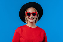 Hipster woman wearing black hat and heart sunglasses