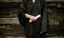 a female graduate holding a diploma 
