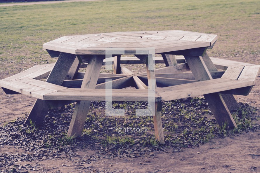 An empty octagonal picnic table in a park 