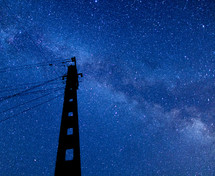 stars in the night sky above power lines 