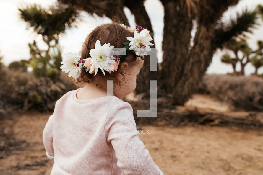a toddler girl with flowers in her hair 