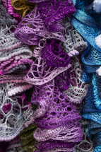 Pile of knitted scarves.