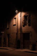 Night time street scene, alley in Europe, traditional wooden window shutters, street light glow