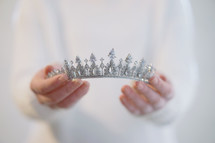 a woman holding a tiara 