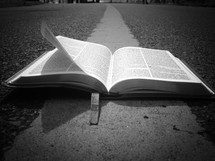 open Bible on the center lines of a road 