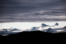clouds over snow capped mountain peaks 