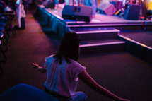 a woman kneeling in front of a stage 
