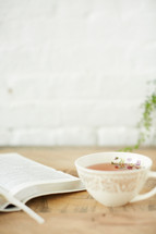 open Bible and tea cup on a table 