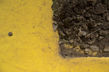 Dirt in corner of yellow pavement.
