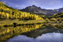Mt Sneffels and Aspen trees reflecting in a beaver pond in the Colorado San Juan Mountain range in the fall season