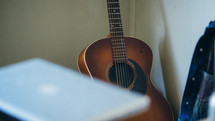 an acoustic guitar in a corner 