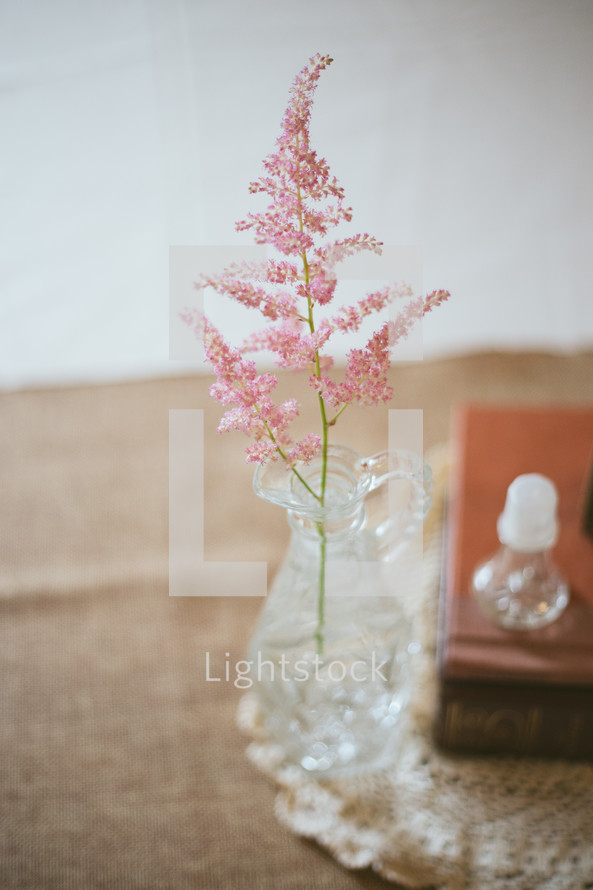 Flowers in a vase on a table with a Bible.