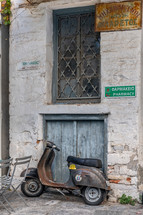 old scooter leaning against a wall 