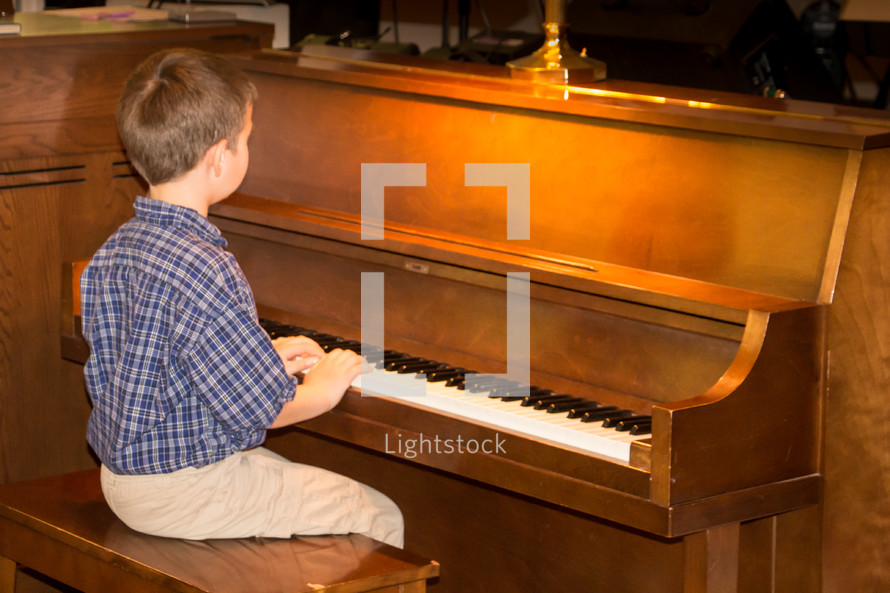 boy playing a piano 