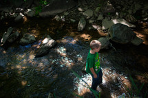 a boy walking in a stream 