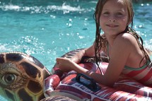 a little girl on a pool float in summer 