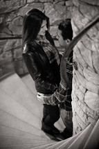 a couple standing in a stairway looking into each other's eyes