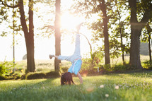a little girl doing a cartwheel in the grass