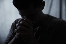 man praying in darkness