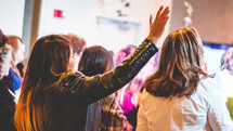 women with raised hands at a conference 