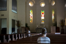 a woman praying in an empty church 
